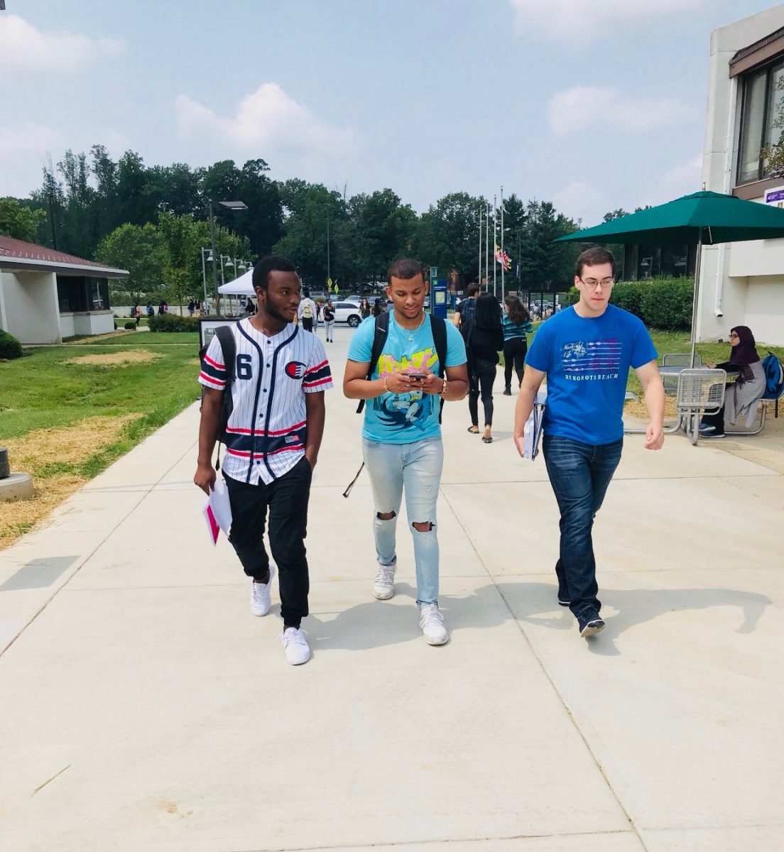 A group of three students walk together.